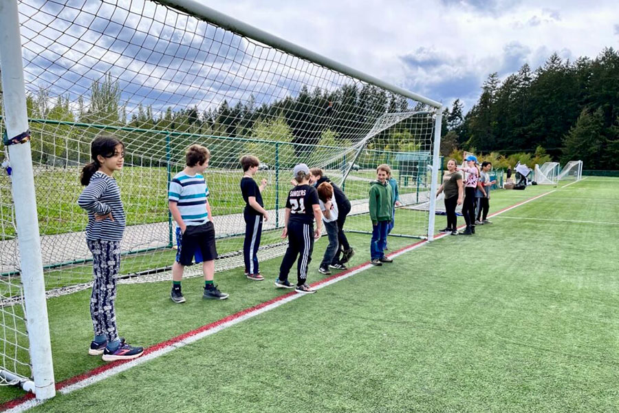 Elementary students playing soccer during PE