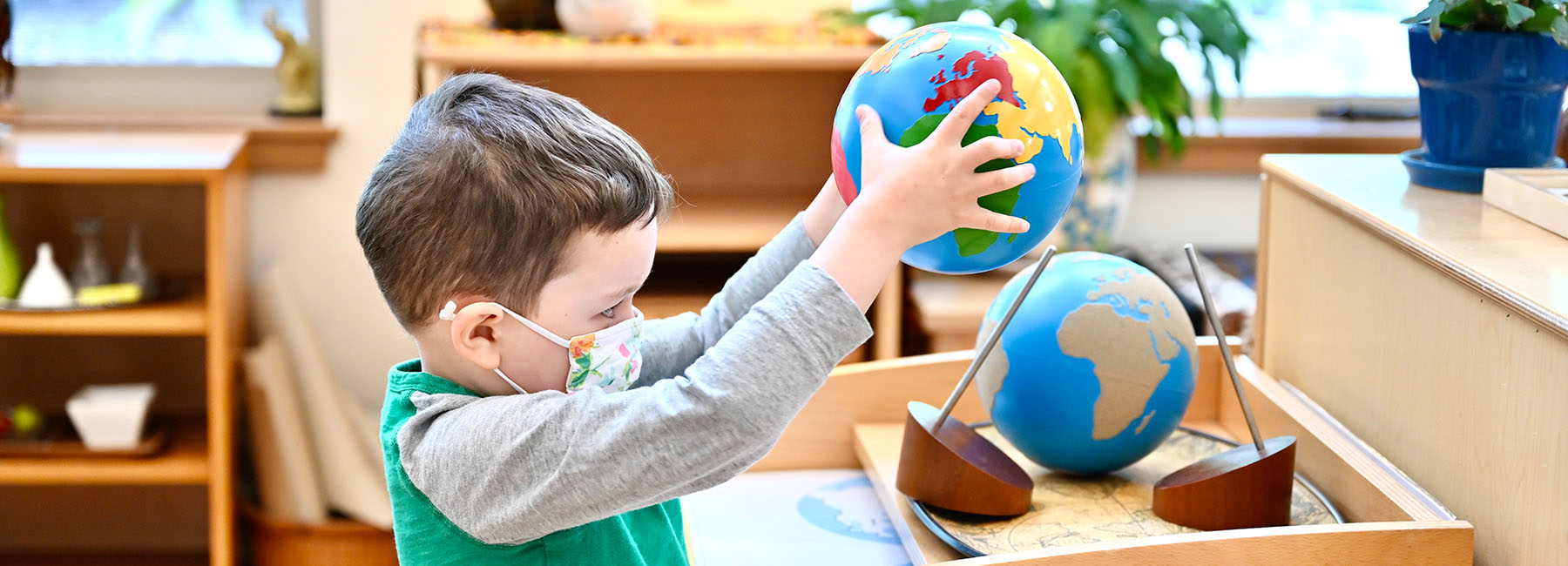 Primary-age student holding a globe