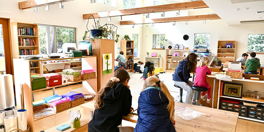 Elementary students studying around group tables