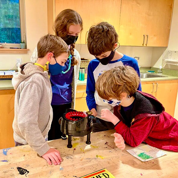 Elementary students huddled around science project