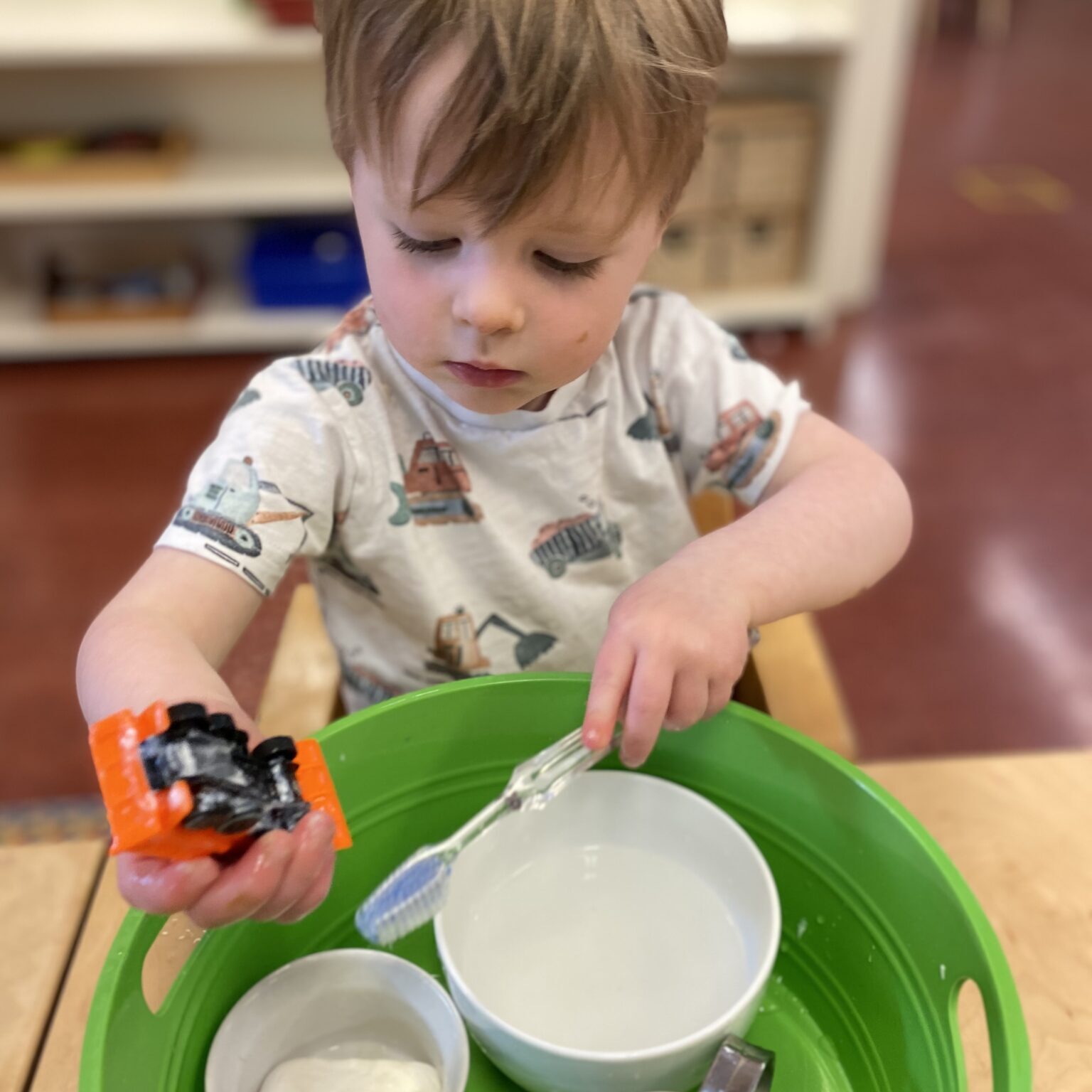 Toddler plays with bowls in a personal play station